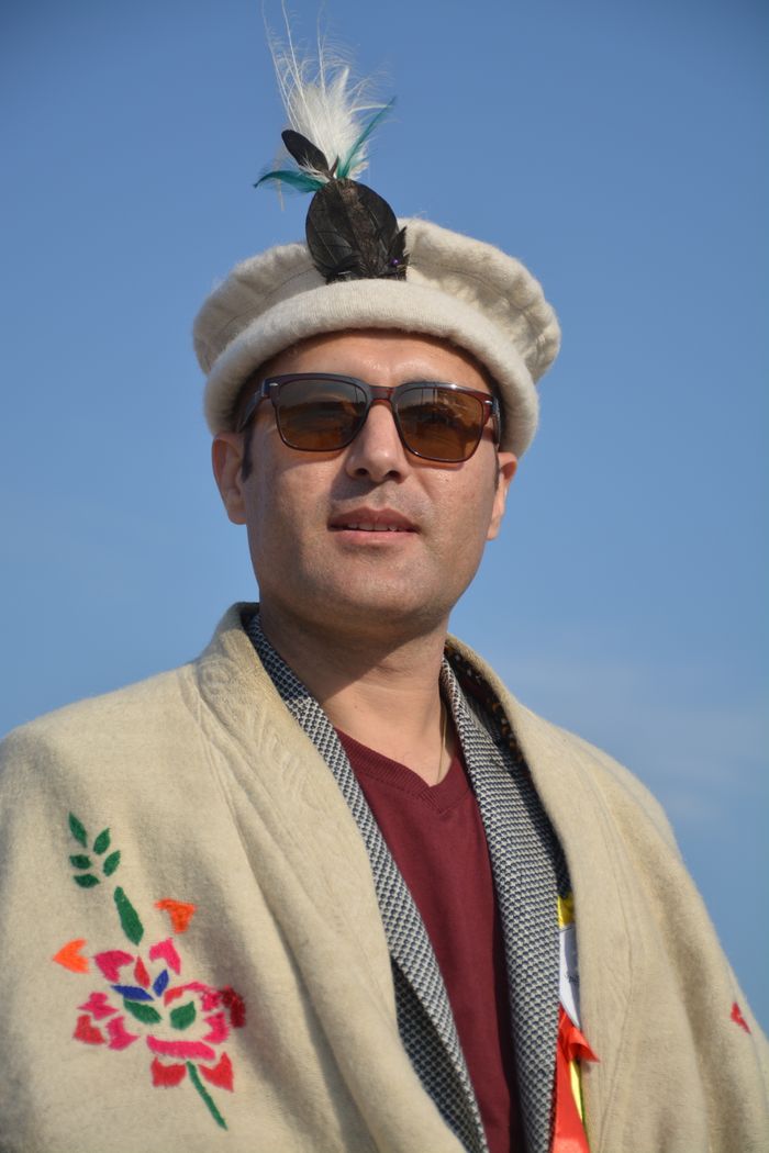 Portrait of a man wearing traditional Gilgit-Baltistan attire with embroidered designs.